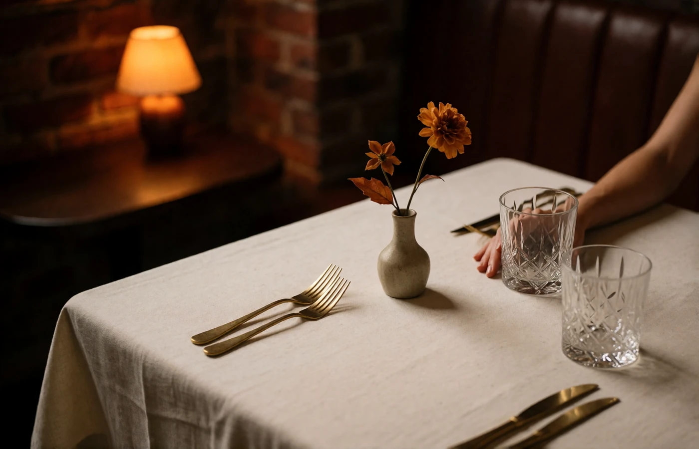Quiet corner table set for dinner in an upscale Columbus restaurant with crystal glasses and brass cutlery